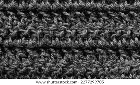 Black texture wool close-up, woven cloth, knitted fabric. Black knit cloth structure macro close up view.