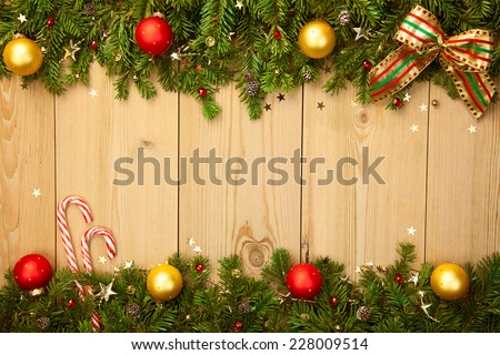 Christmas background with firt-ree, candies, baubles and stars on wood 