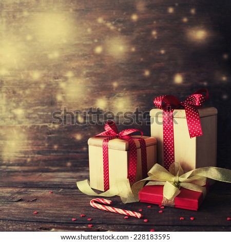 Christmas presents with red ribbon on dark wooden background in vintage style 