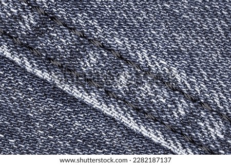 Denim close-up and seam with black threads background wallpaper, uniform texture