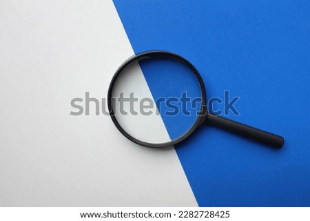 black frame a magnifying glass on Rectangle shape colored paper white and blue background