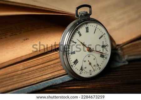 Old vintage watch on books background close up.