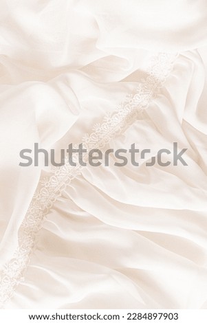 Details of chiffon beige fabric of the bride's dress with soft waves and lace. wedding background. elegant soft background texture. a copy space.
