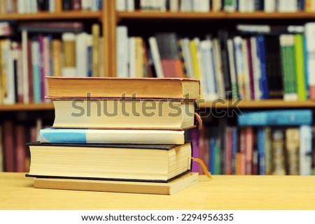 Pile of books on table in library