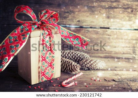 Christmas present with candy canes on dark wooden background in vintage style 