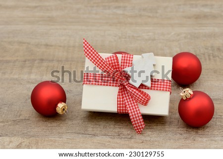 Present and xmas balls lying on wood