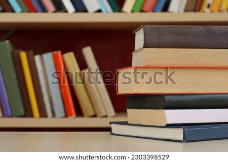 pile of books with stack of book on bookshelf background. education and learning concept