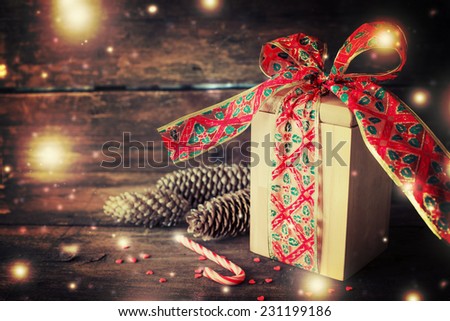Christmas present with candy canes on dark wooden background in vintage style  