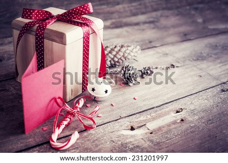 Christmas present with candy canes on dark wooden background in vintage style  