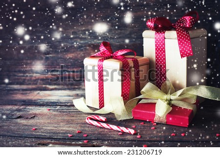 Christmas presents with red ribbon on dark wooden background in vintage style
