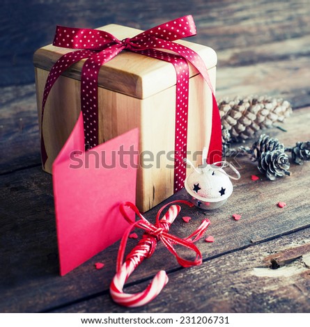 Christmas present with candy canes on dark wooden background in vintage style 