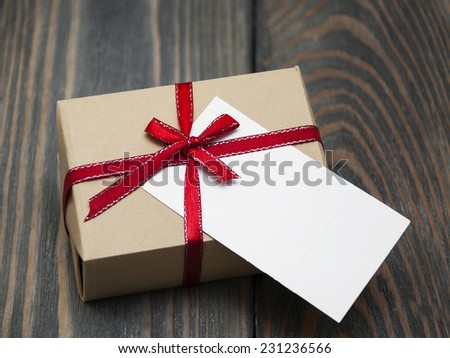 vintage gift box package with blank  tag on old wooden background