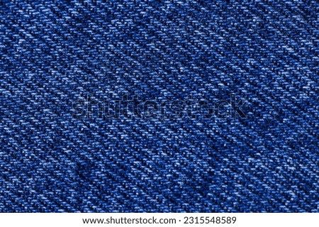 Texture of denim fabric in dark blue close-up.