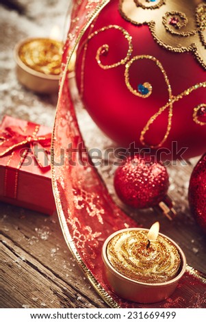 Christmas background with beautiful red balls, golden candles and snow