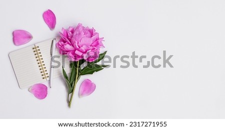 Beautiful peony flowers and laptop on a white background. Holiday background. View from above. Copy space.