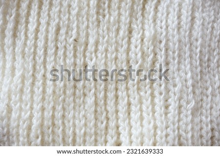 Knitted white wool fabric. Knitted texture. Knitted background.
