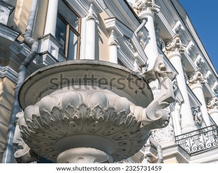 A vase made of stucco. A pot on the facade of a mansion built in the 19th century. Ancient architecture with stucco on the facade. Decorated interior of the facade of an old mansion.