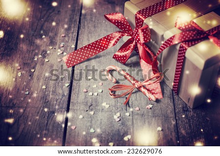 Christmas presents with red ribbon on dark wooden background in vintage style / Selective focus