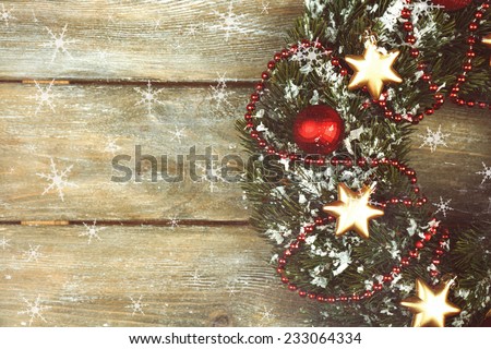Green Christmas wreath with decorations on wooden background