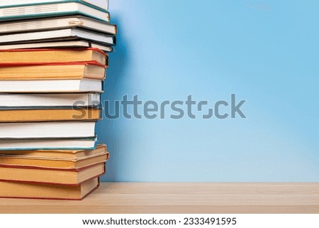 Composition with vintage old hardback books, diary on wooden table and blue background. Books stacking. Back to school. Copy Space. Education background.