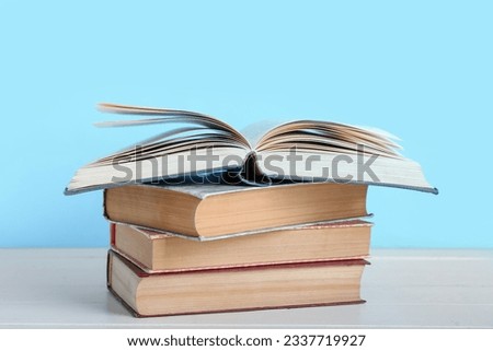 Stack of books on table against blue background