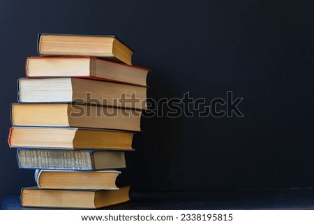 Close-up of stack of books on black background. Place for text, concept of starting school, back to school, education