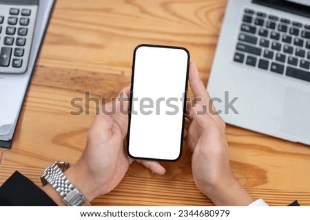 Top view of a businesswoman using his smartphone at his desk. smartphone white screen mockup