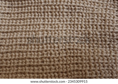 Closeup photo of knitted fabric texture. Pattern of beige handmade knitting. Warm and comfort background