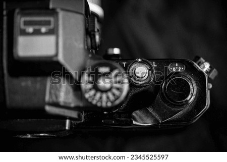 A grayscale of a film rewind crank of a camera