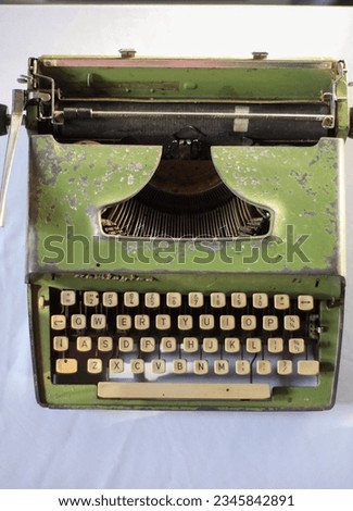 Vintage green typewriter over a white background.