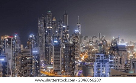 View of various skyscrapers in tallest recidential block in Dubai Marina aerial day to night transition with artificial canal. Many towers and yachts after sunset
