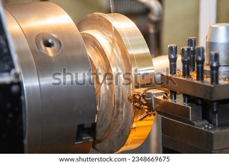 Closeup scene the lathe machine finish cut the brass parts by lathe tools. The metalworking process by turning machine.