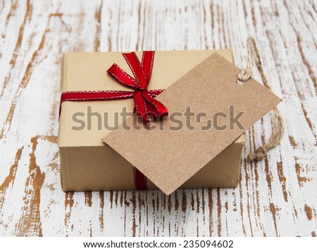 vintage gift box package with blank  tag on old wooden background