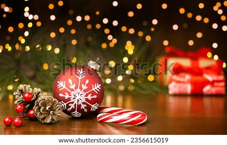 Christmas presents, red Christmas bauble, cones   and red candy cane on wooden festive background