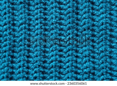 The texture of the pattern is made of wool blend yarn, berquoise color. Warm wool blend yarn close-up.