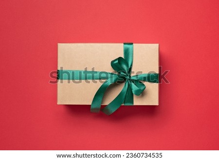 gift box with green ribbon on red background
