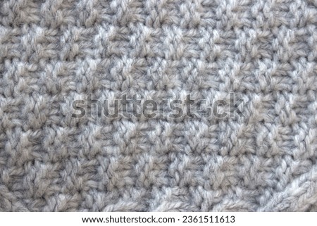 Texture of gray knitted sweater with braids