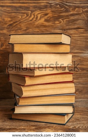 Stack of old hardcover books on wooden background