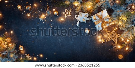 Christmas Lights With Gift Boxes Ornaments And Fir Branches On Blue Background