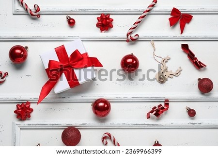 Christmas balls with gift box and candy canes on white background