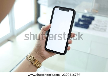 Closeup of hand holding black smartphone white screen.