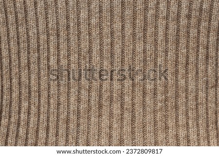 horizontal texture of a knitted beige woolen fabric as a warm background