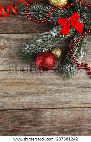 Branch of Christmas tree with balls on grey wooden background