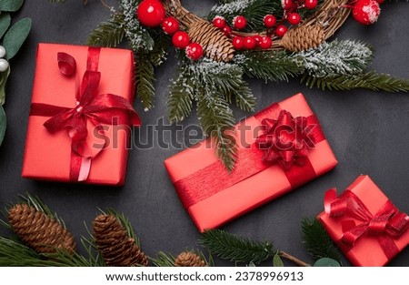 Christmas wreaths, fir branches and gifts on a black background. View from above