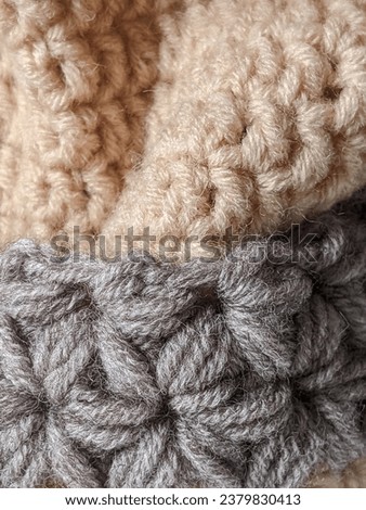 Knitted product made of woolen yarn with a clear pattern in pleasant colors. Texture of a knitted blanket.