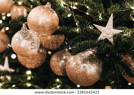 Magic cozy details, festive winter background. Christmas tree decorated with golden shiny Christmas balls and star.