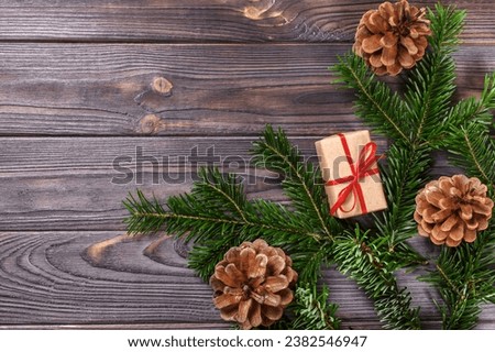 Fir tree with christmas decorations and gift boxes on wooden background.