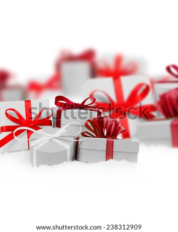 Group of presents with red ribbons on white background, defocused presents behind; white space for text