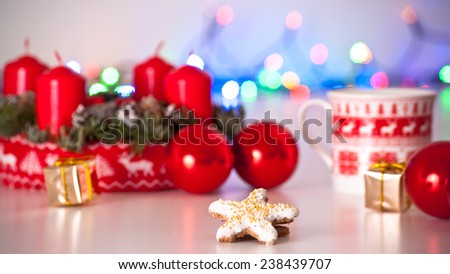 Homely red and white christmas decoration with candles, advent wreath, balls, candy star cookies
