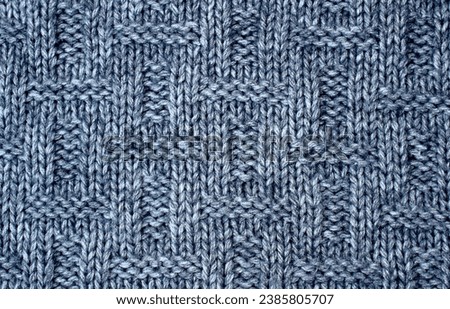 Knitted design, gray background. Knitted structure. Top view.